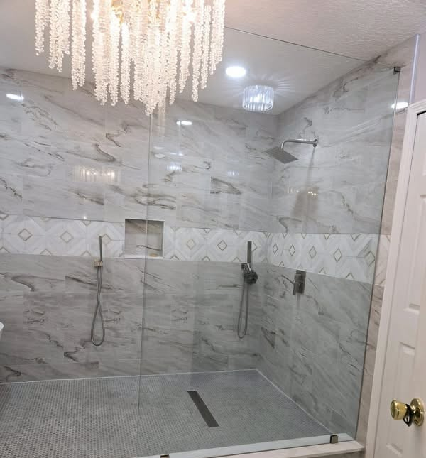 Marble-look tile walk-in double shower with glass panel and linear drain